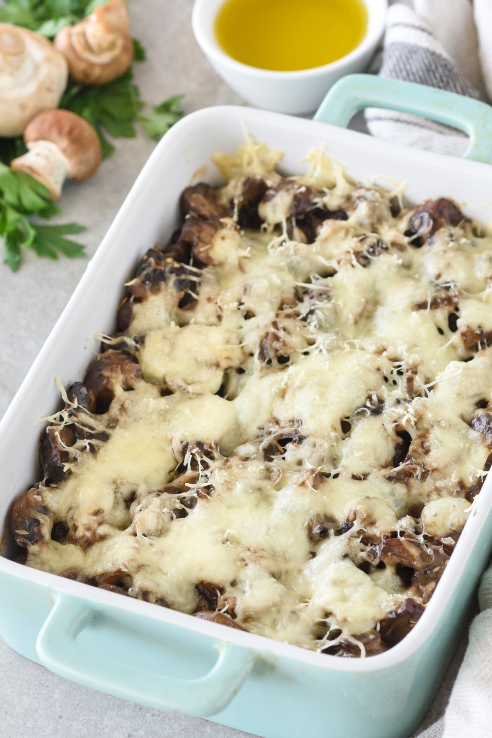 A baking dish filled with freshly baked mushroom casserole covered in melted cheese.