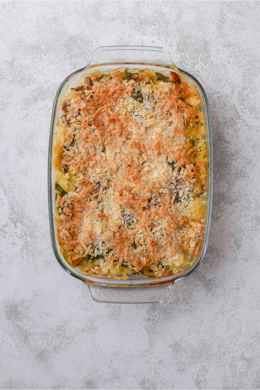 A baking dish filled with chicken cauliflower casserole covered in a layer of bread crumbs.