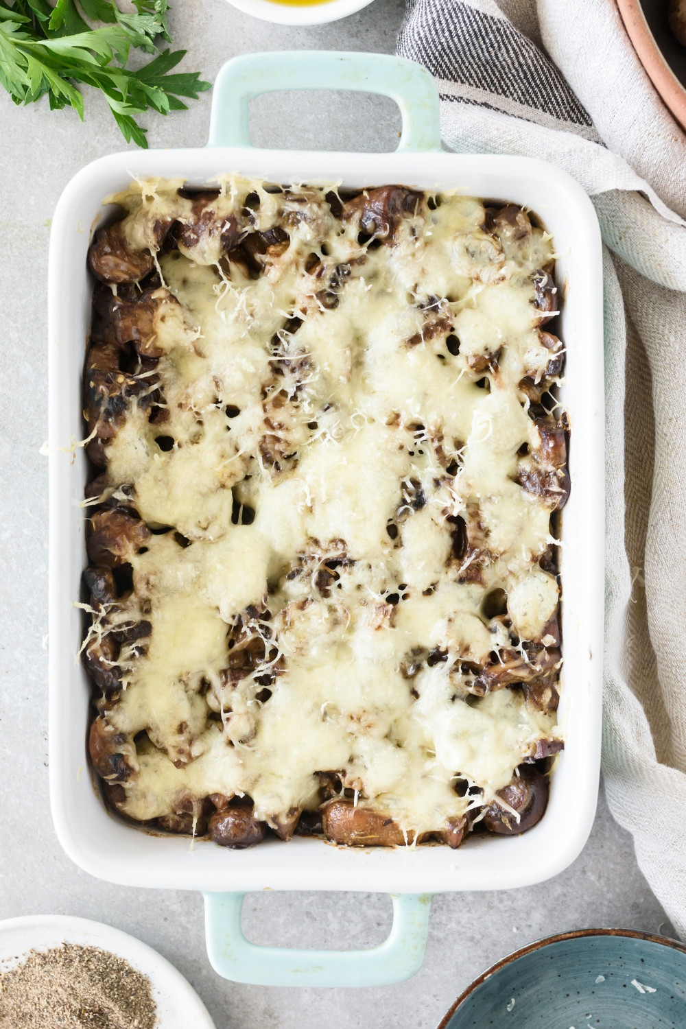 A baking dish filled with freshly baked mushroom casserole covered in melted cheese.
