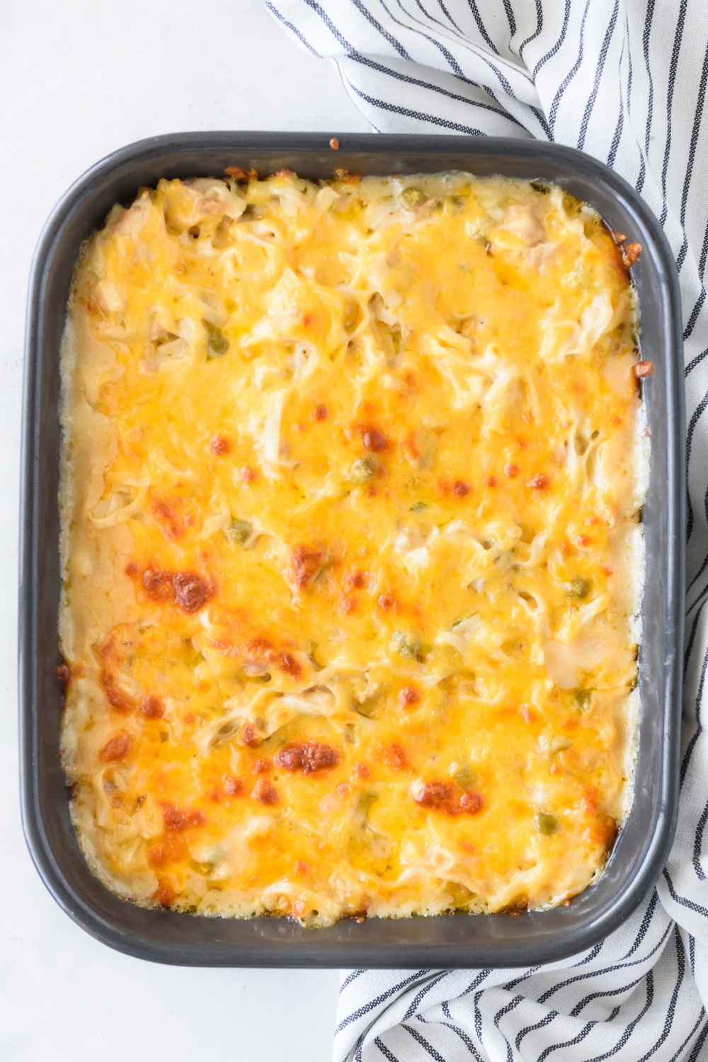 A baking dish filled with freshly baked tuna casserole covered in melted cheese.