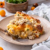 A serving of chicken and biscuit casserole piled high with a fork on the plate.
