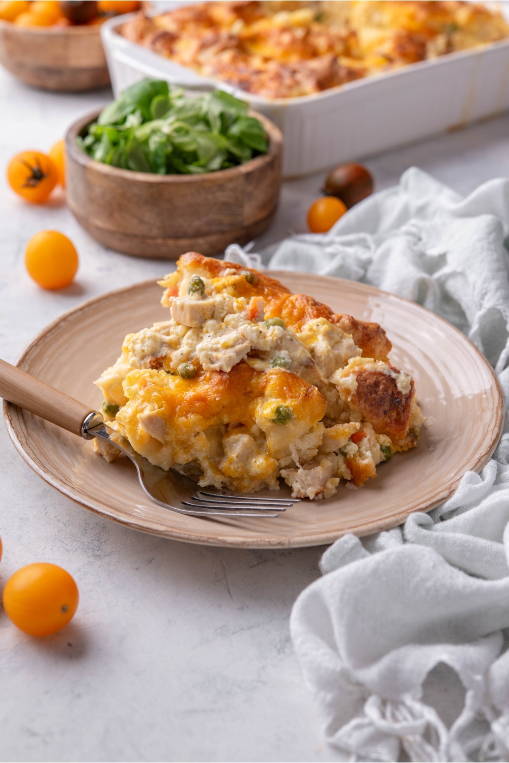 A serving of chicken and biscuit casserole piled high with a fork on the plate.