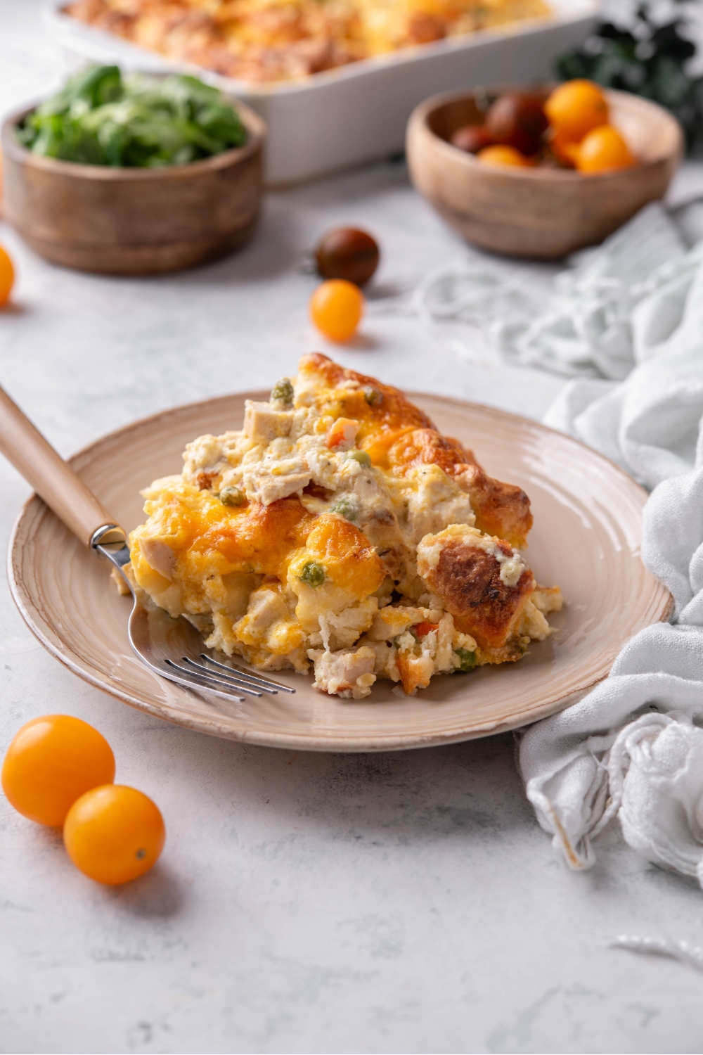 A serving of chicken and biscuit casserole piled high with a fork on the plate.