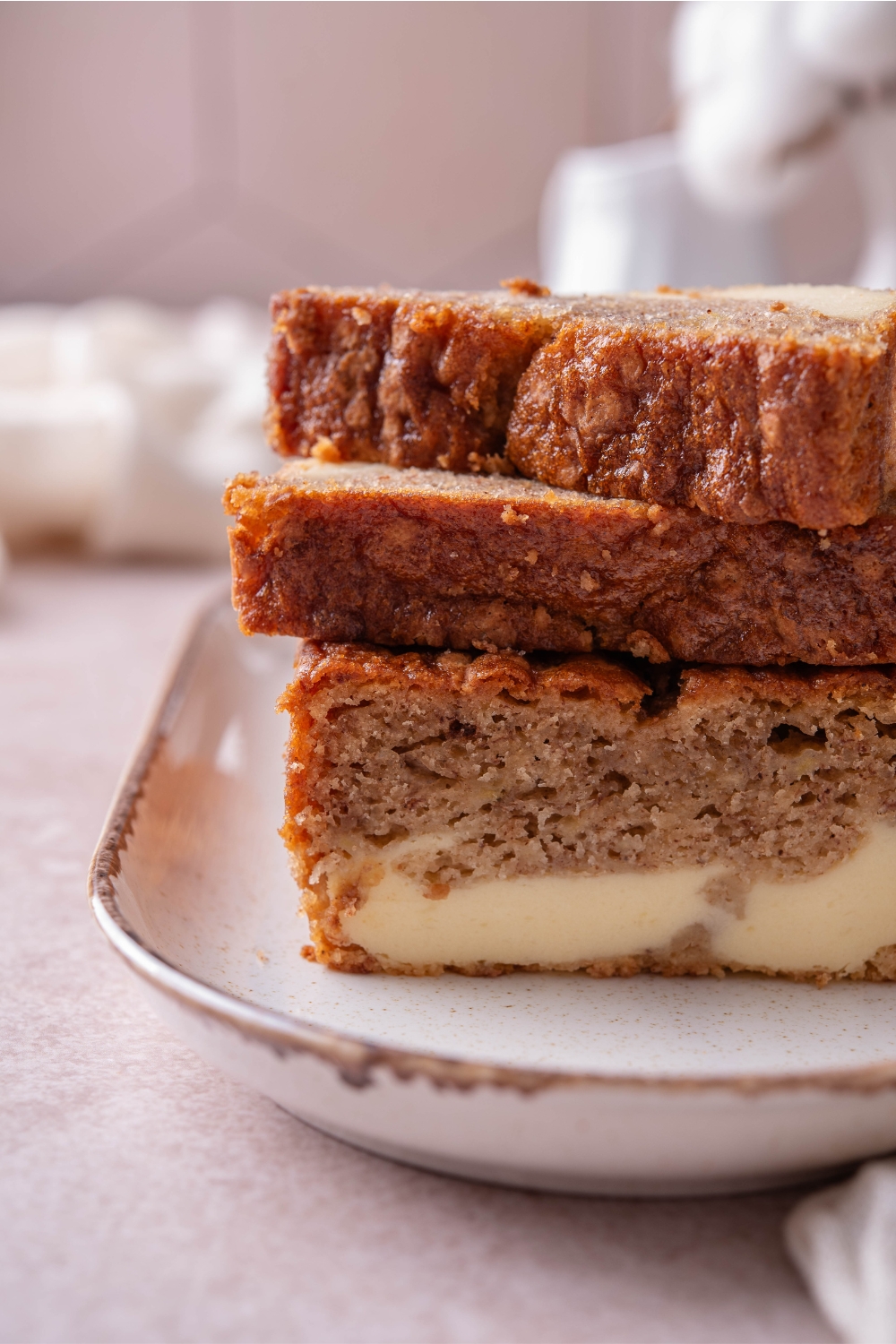 Three slices of cream cheese banana bread stacked on top of each other.