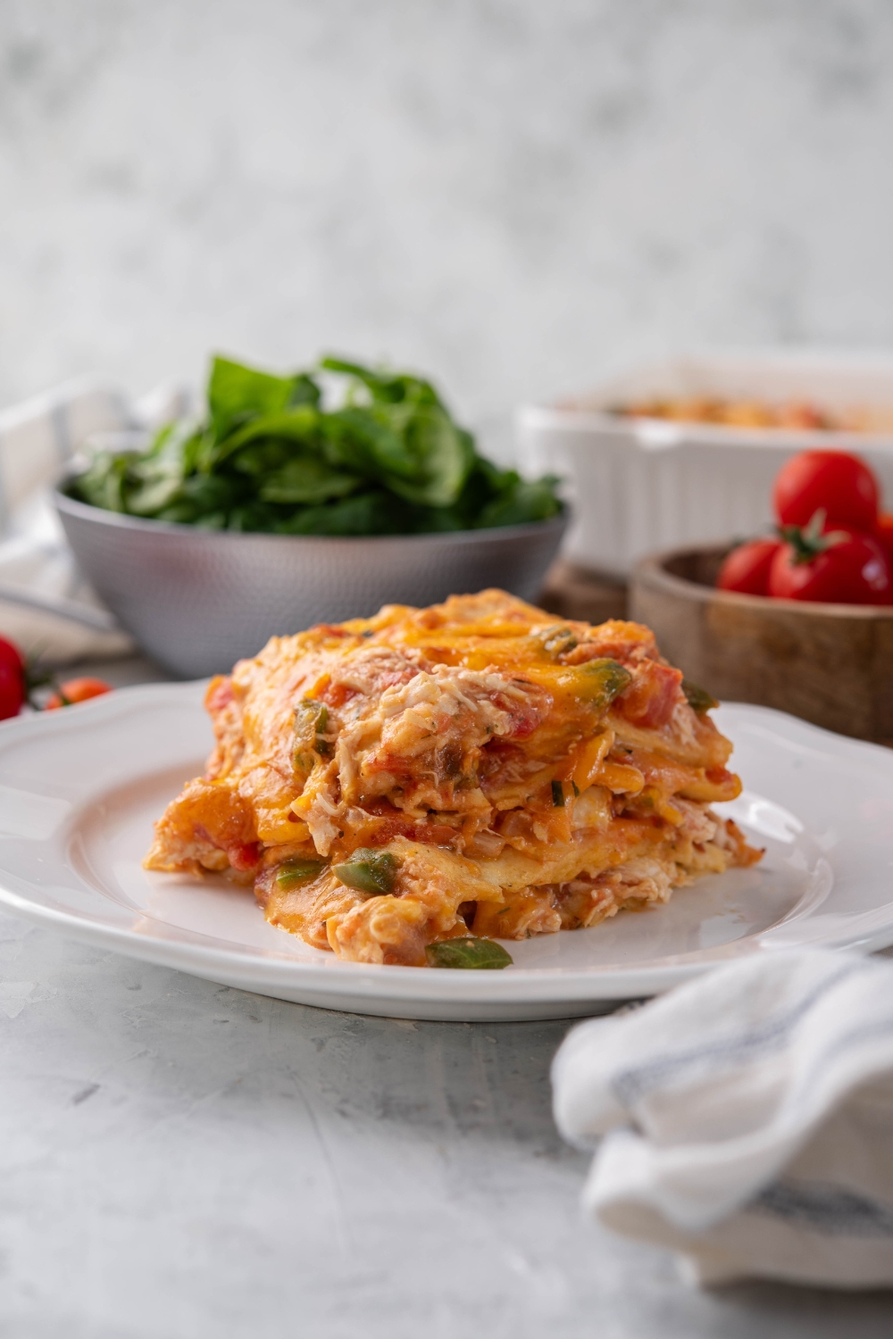 A square serving of king ranch chicken casserole covered in melted cheese.