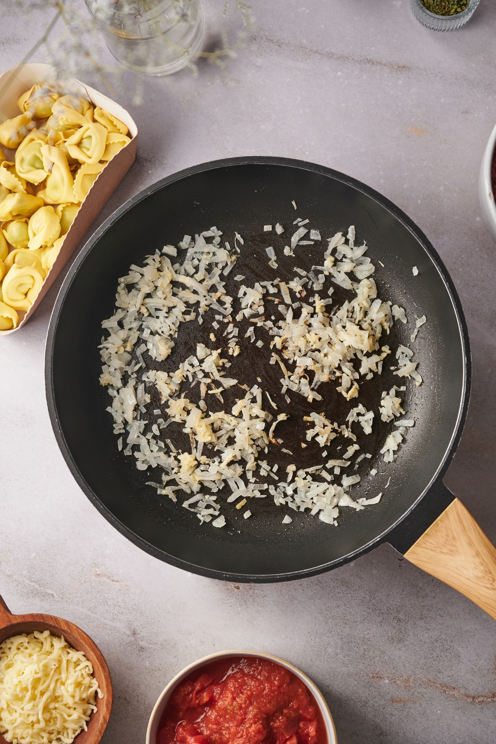 A skillet with diced onions cooking.