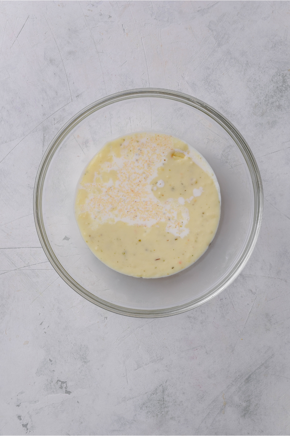 A clear bowl with a creamy soup mixture in it.