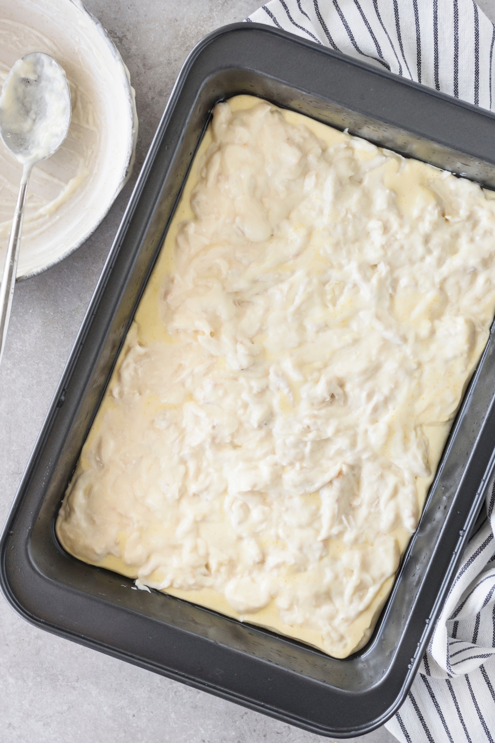 A baking dish filled with shredded chicken in a creamy sauce.