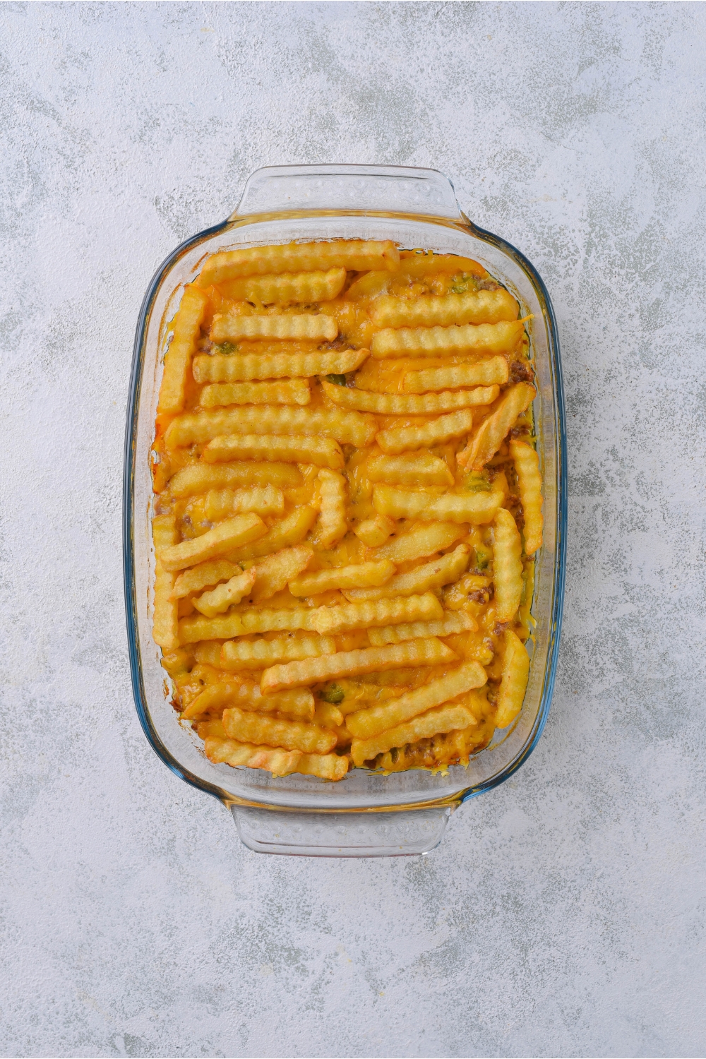 A baking dish filled with french fry casserole.