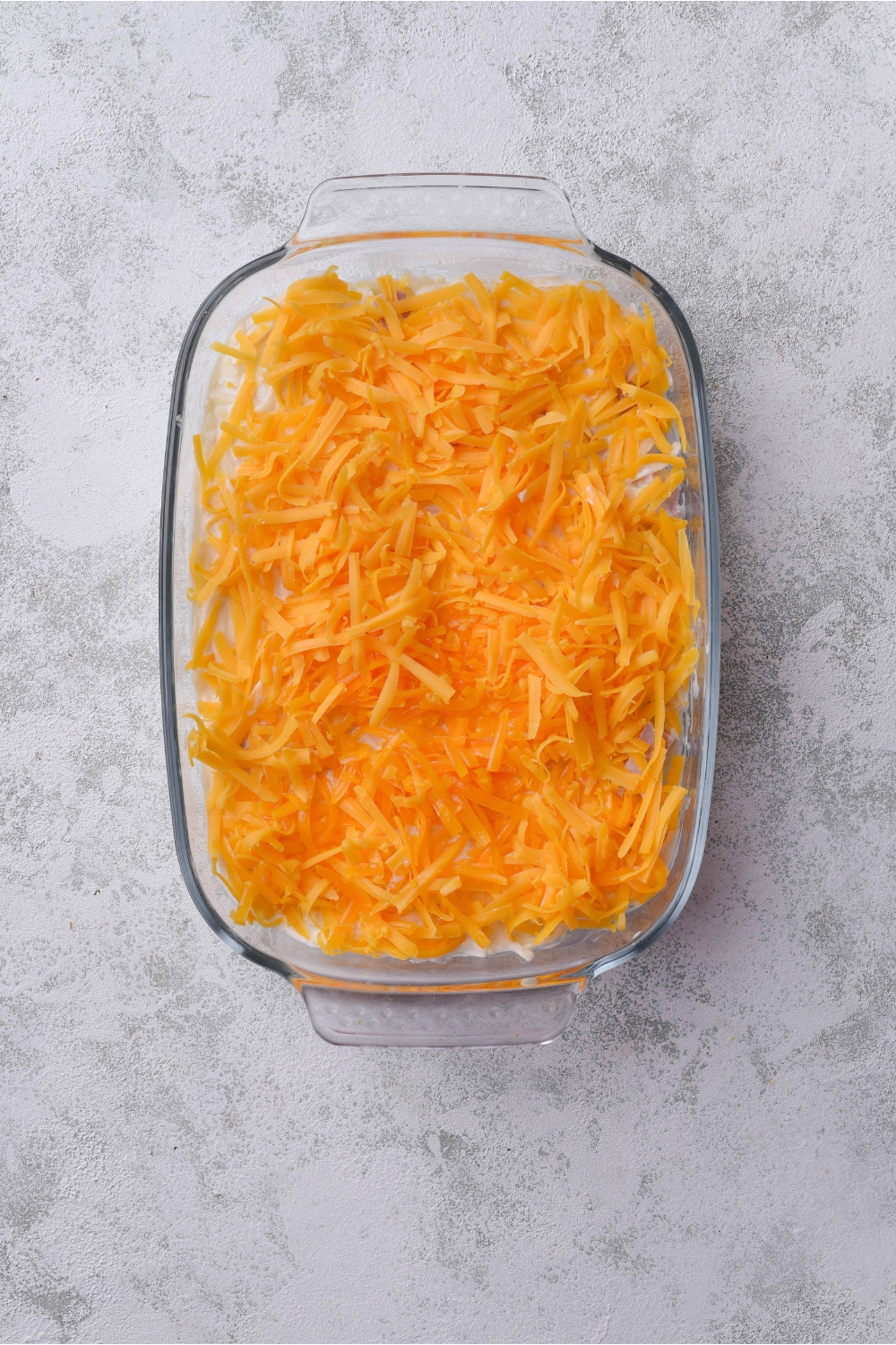 A casserole covered in shredded cheese.