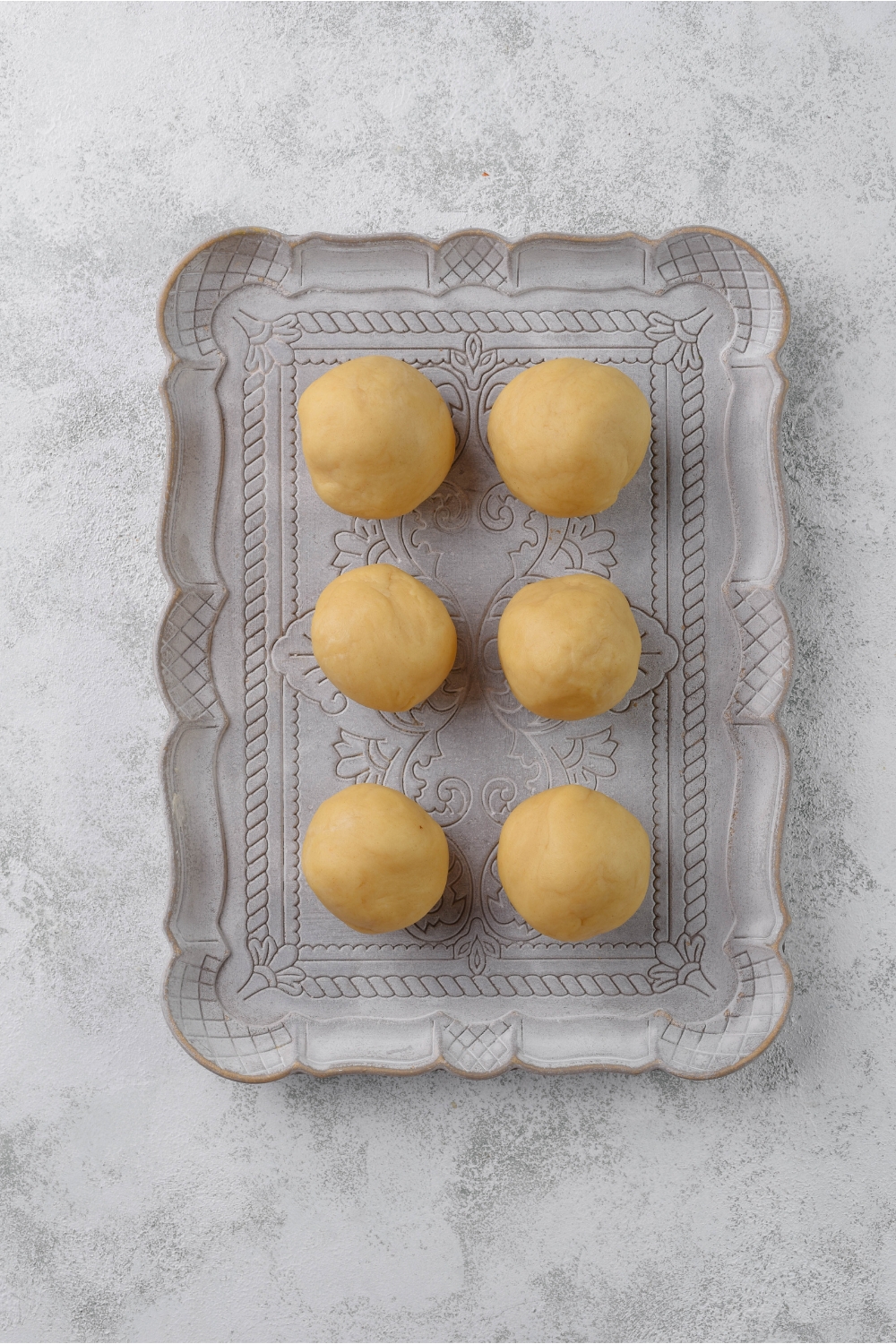 A platter with six evenly-sized dough balls.
