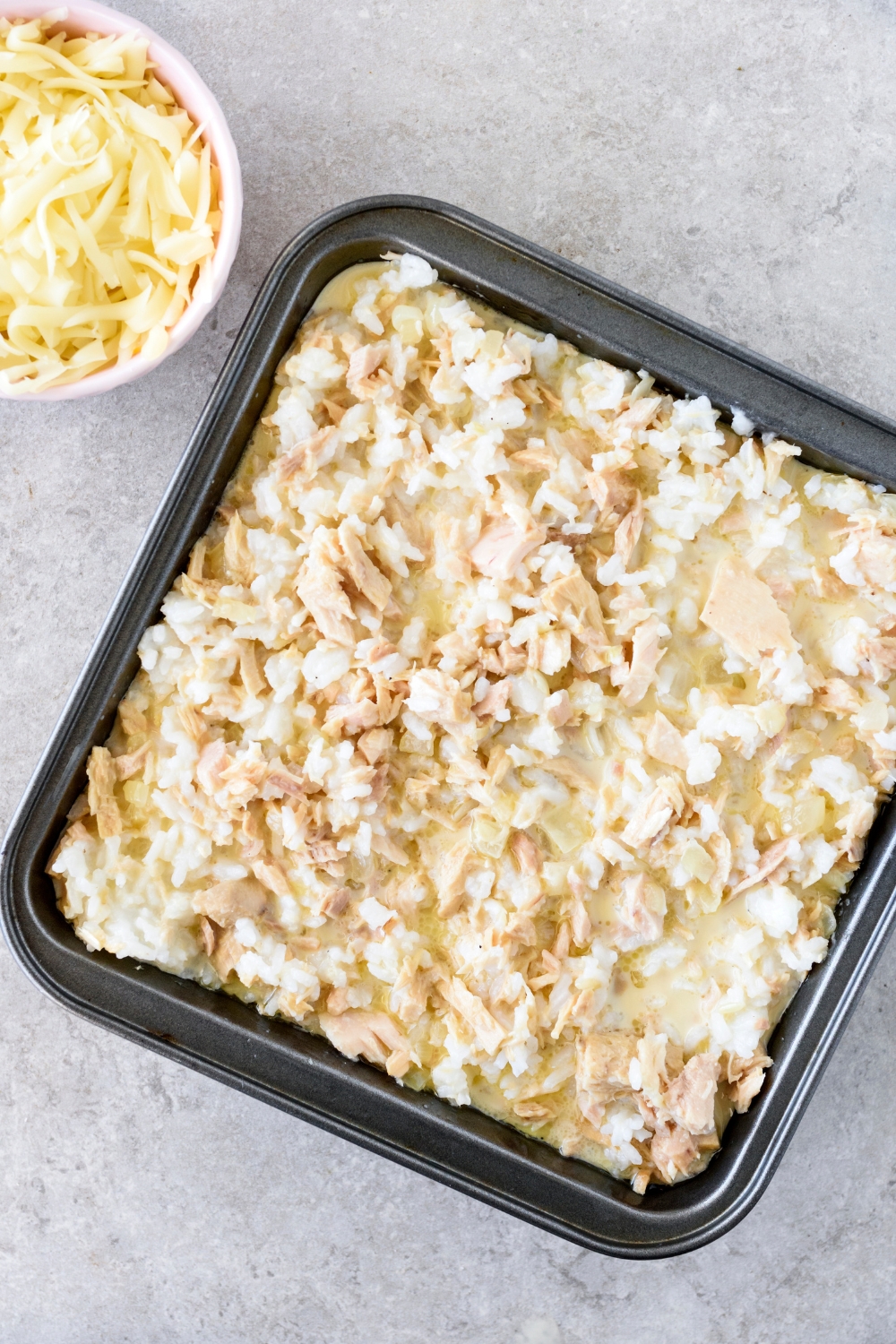 A baking dish filled with canned tuna and white rice in a creamy sauce.