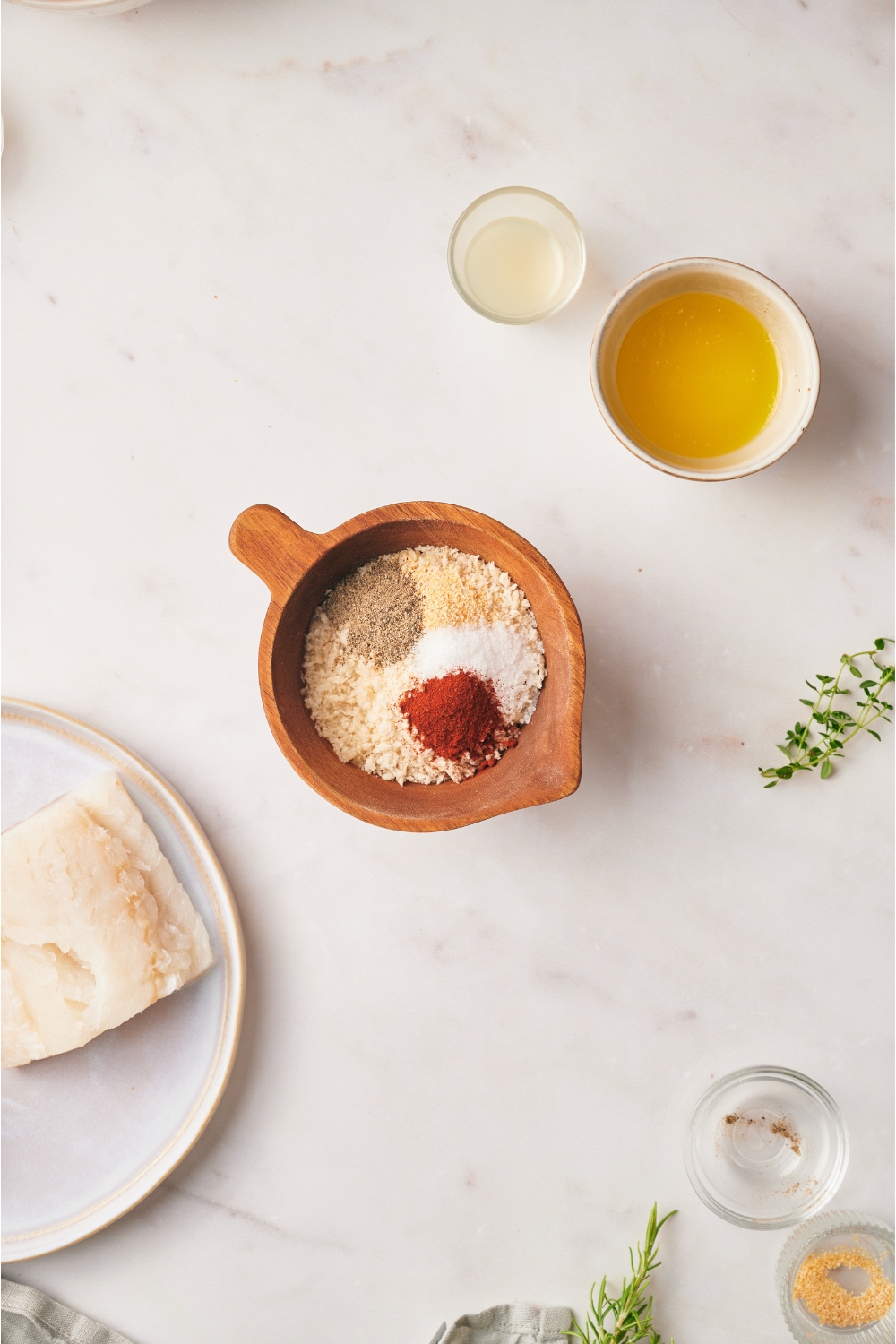 A wood bowl filled with bread crumbs and an assortment of spices.