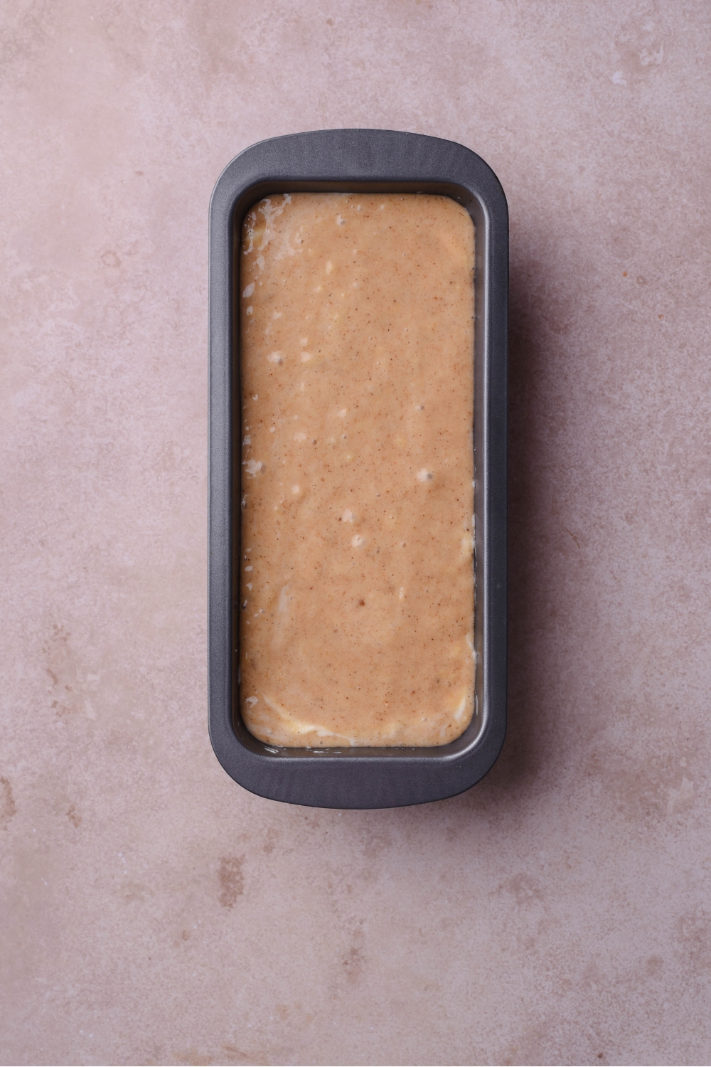 A loaf pan filled with banana bread batter.