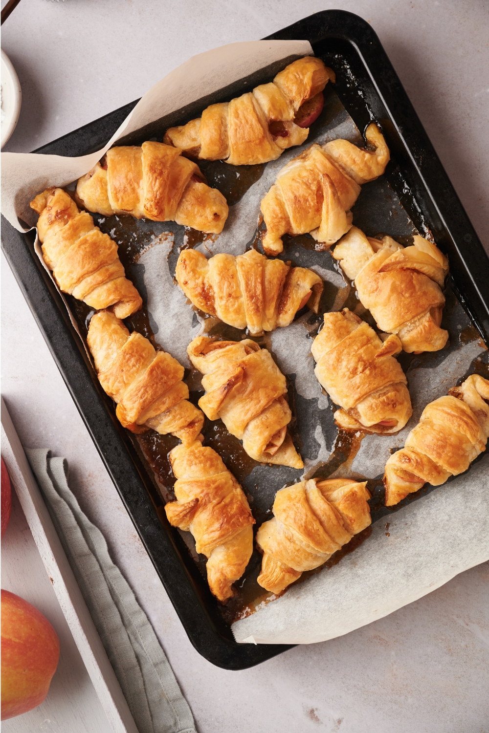 Freshly baked apple turnovers on a baking sheet lined with parchment paper.