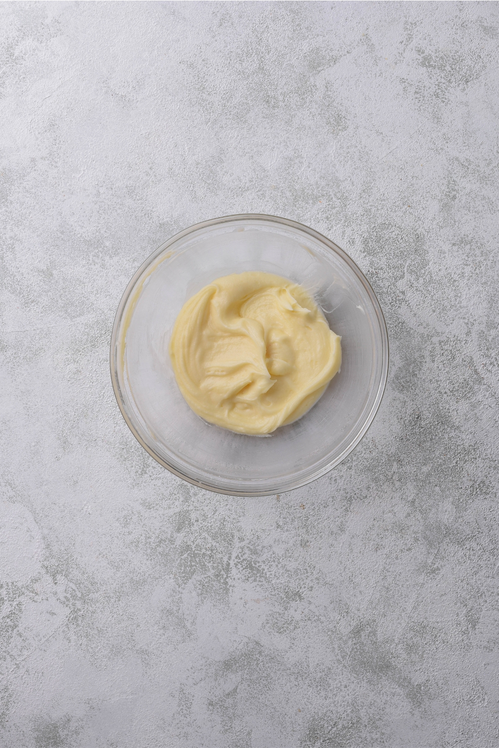 A clear bowl filled with frosting.