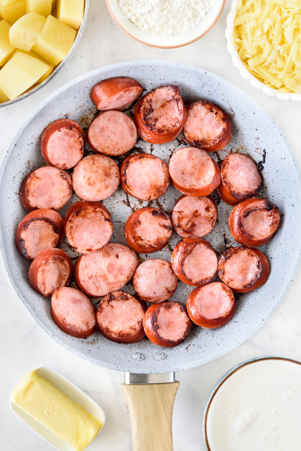A skillet filled with sausages that have been browned.