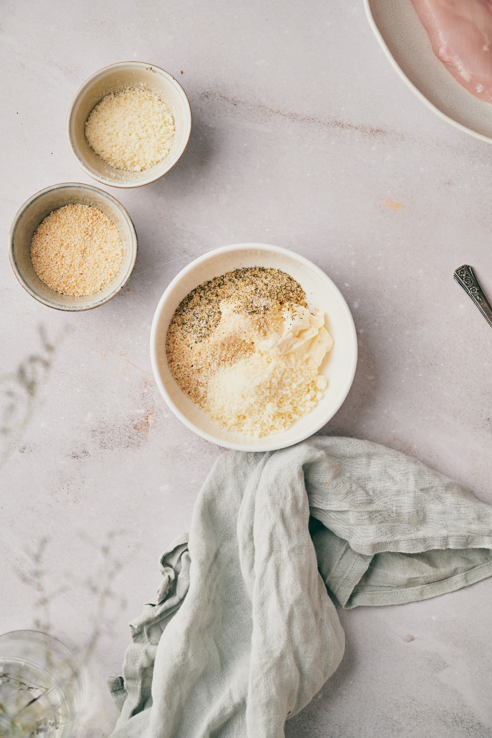 A bowl of mayonnaise mixed with spices and parmesan cheese.