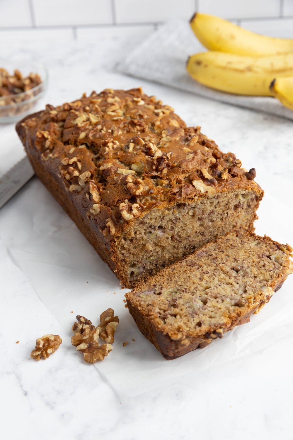 A loaf of banana bread being cut into slices.