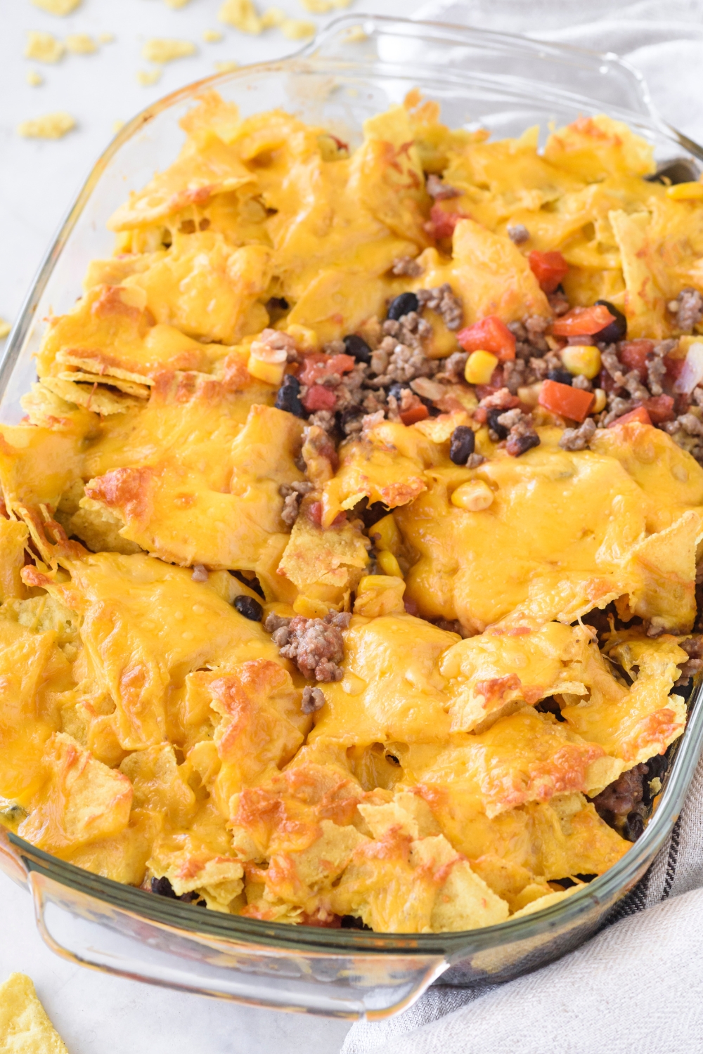 A baking dish filled with freshly baked Tex-Mex casserole covered in melted cheese.