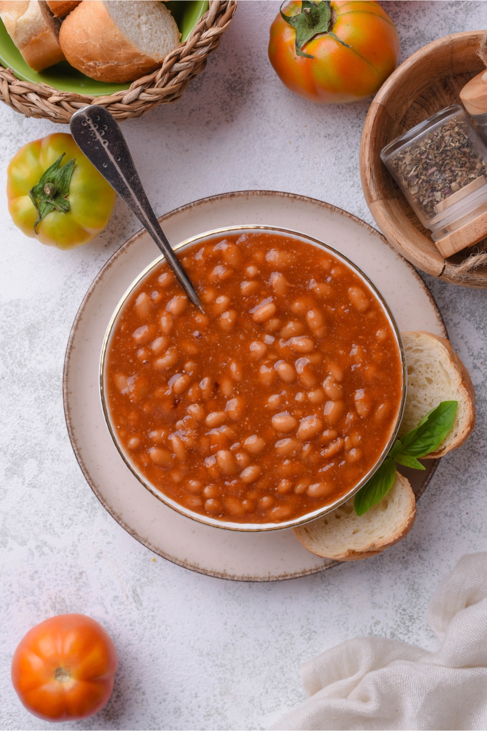 Top view of a bowl of baked beans in a bowl served with two slices of crusty bread.
