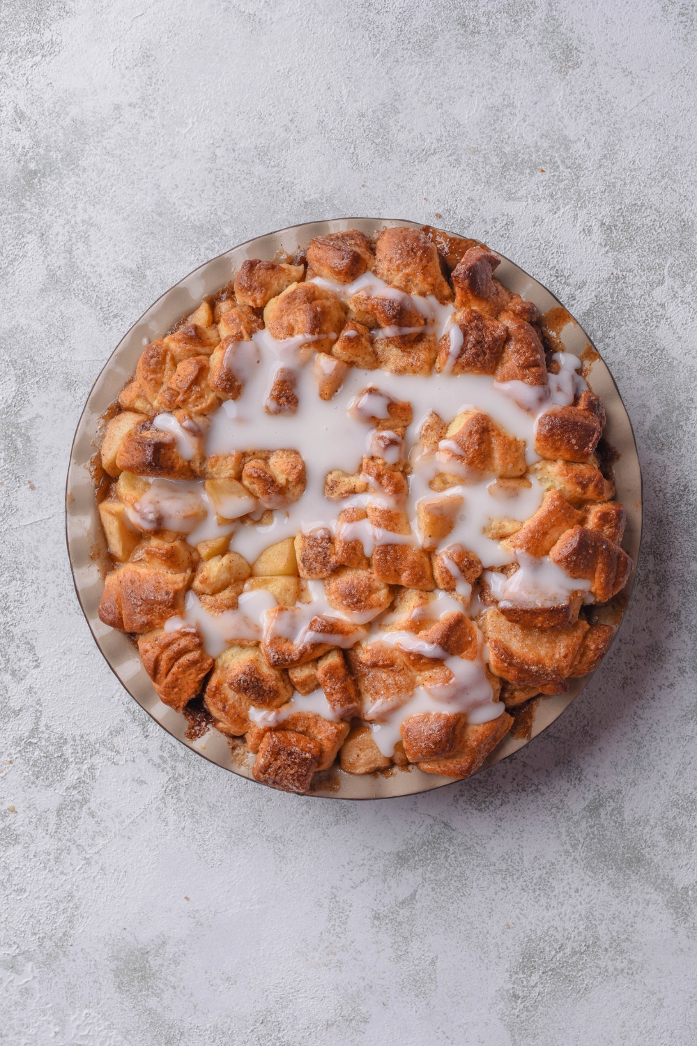 A baking pan with baked apple pie cinnamon rolls.