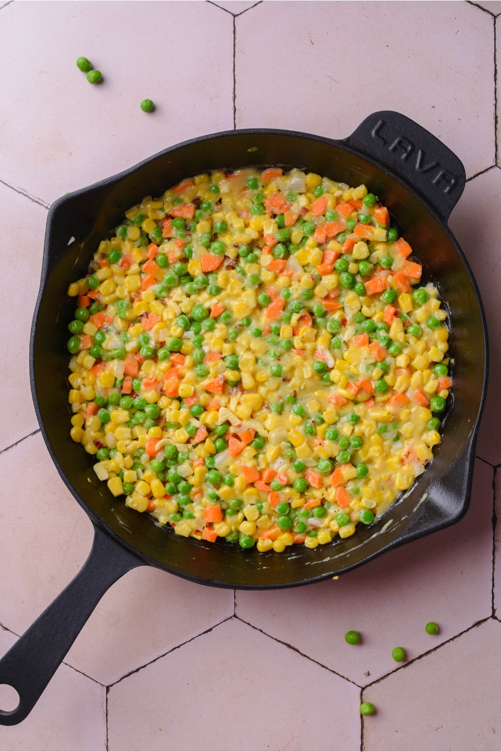 A cast iron skillet with veggies cooking.