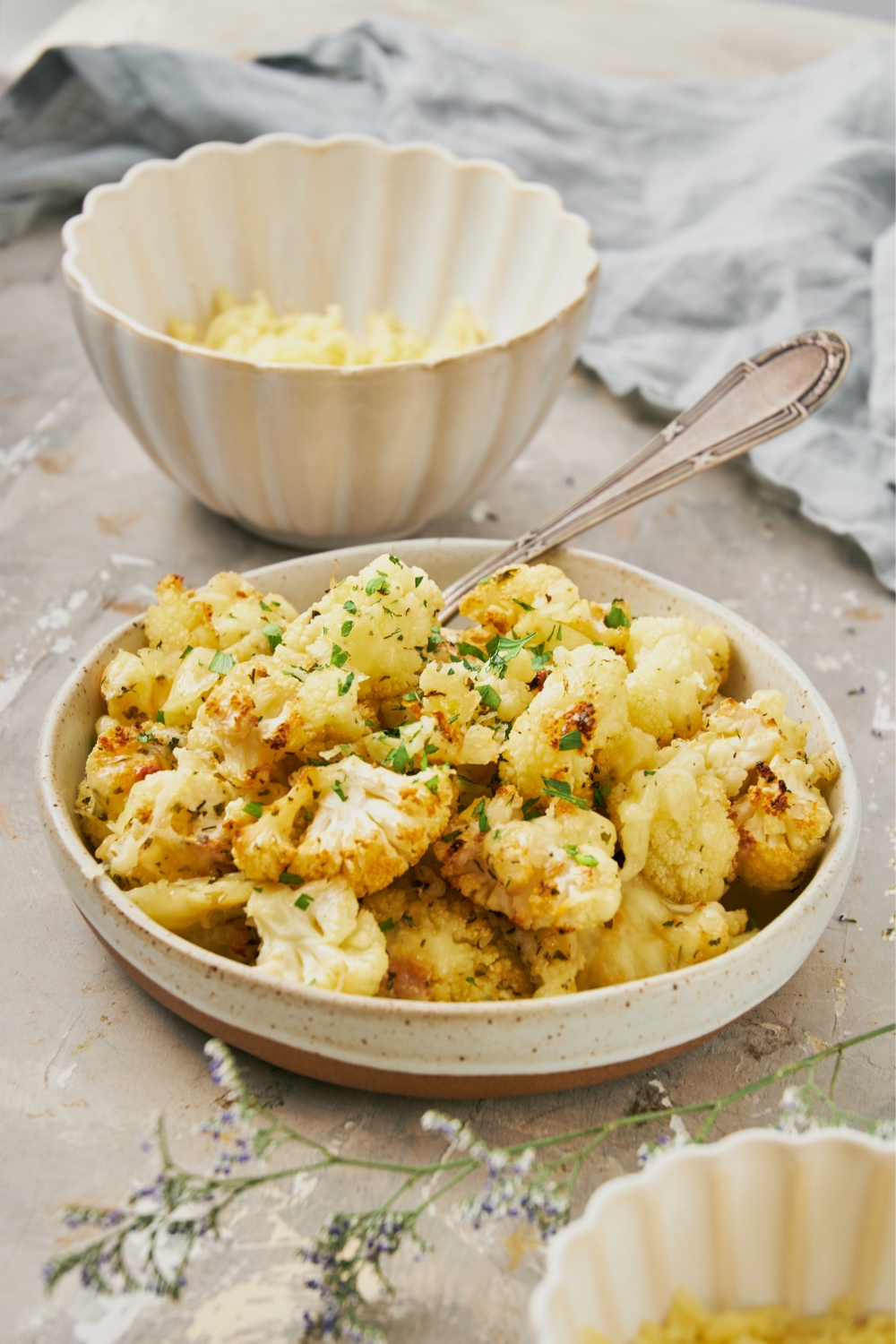 A bowl with cheesy cauliflower and a fork in it.