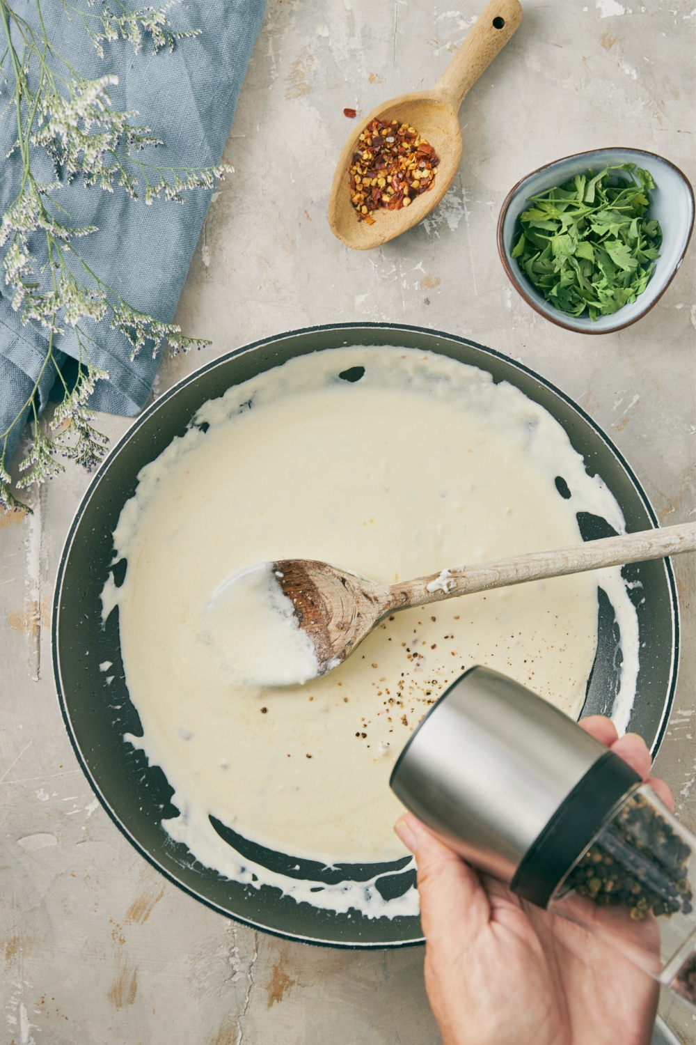 Cream cheese sauce being mixed in a pan with a wooden spoon.