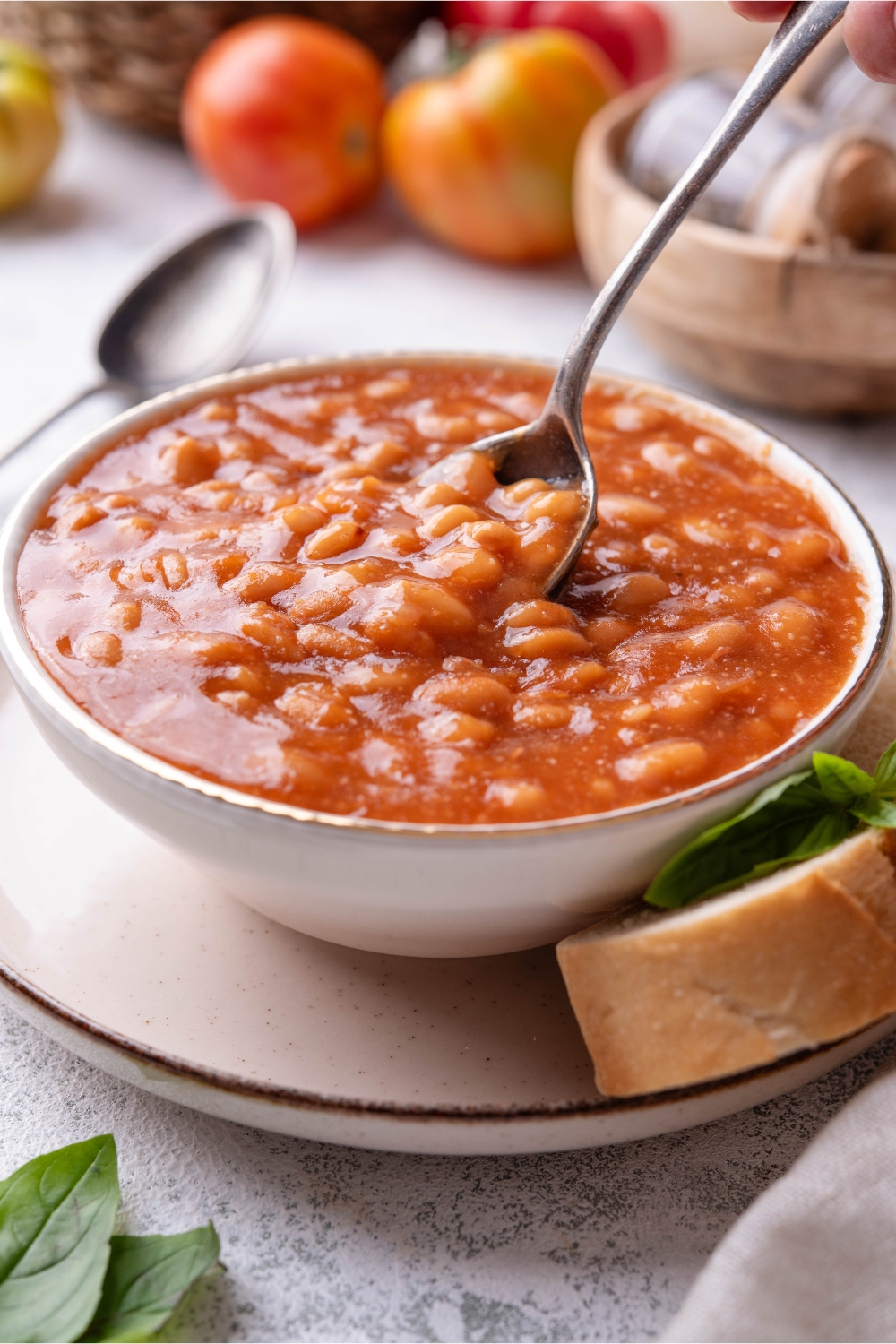 A spoon scooping from a bowl of baked beans.