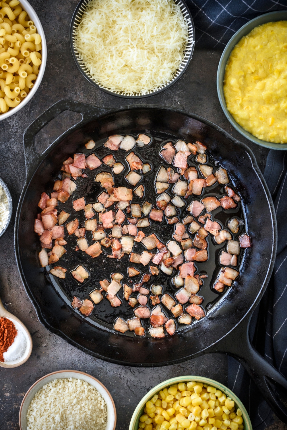 A skillet with bacon cooking.