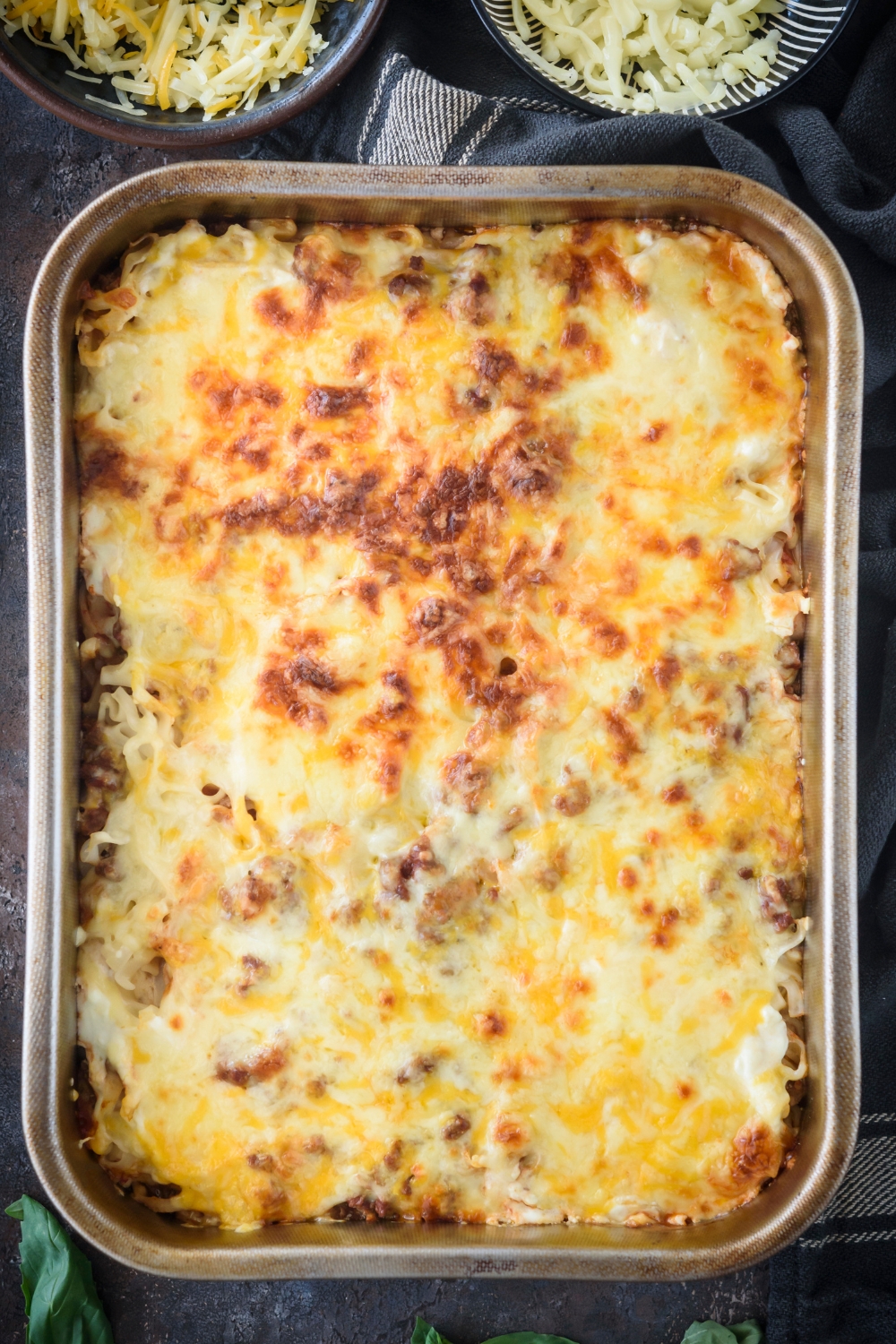 Melted cheese on top of an amish hamburger casserole in a baking dish.