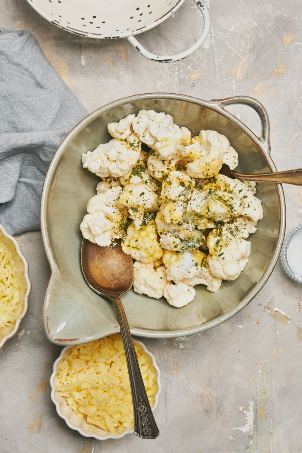 A mixing bowl with cauliflower and seasonings.