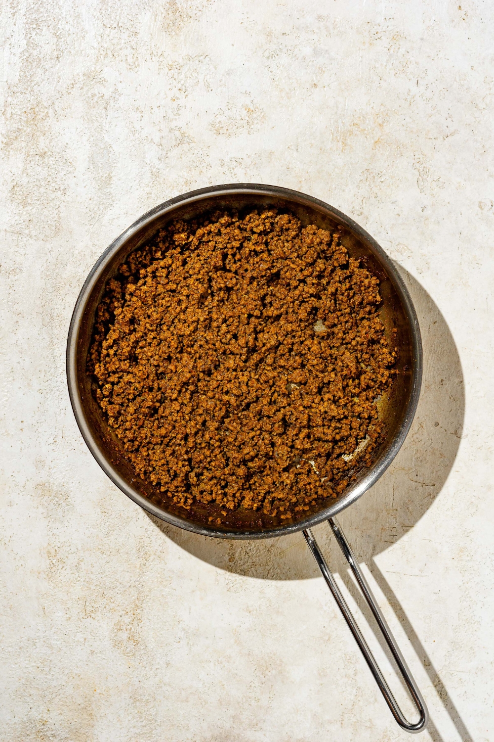 Ground beef cooking in a skillet.