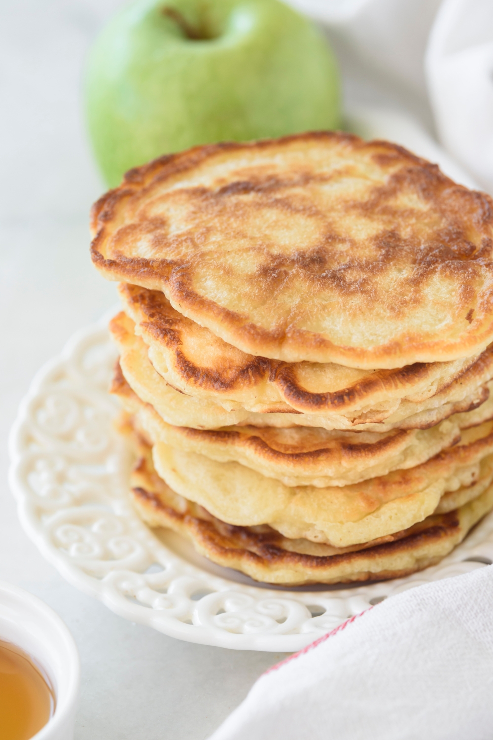 A stack of golden brown pancakes on a white plate.
