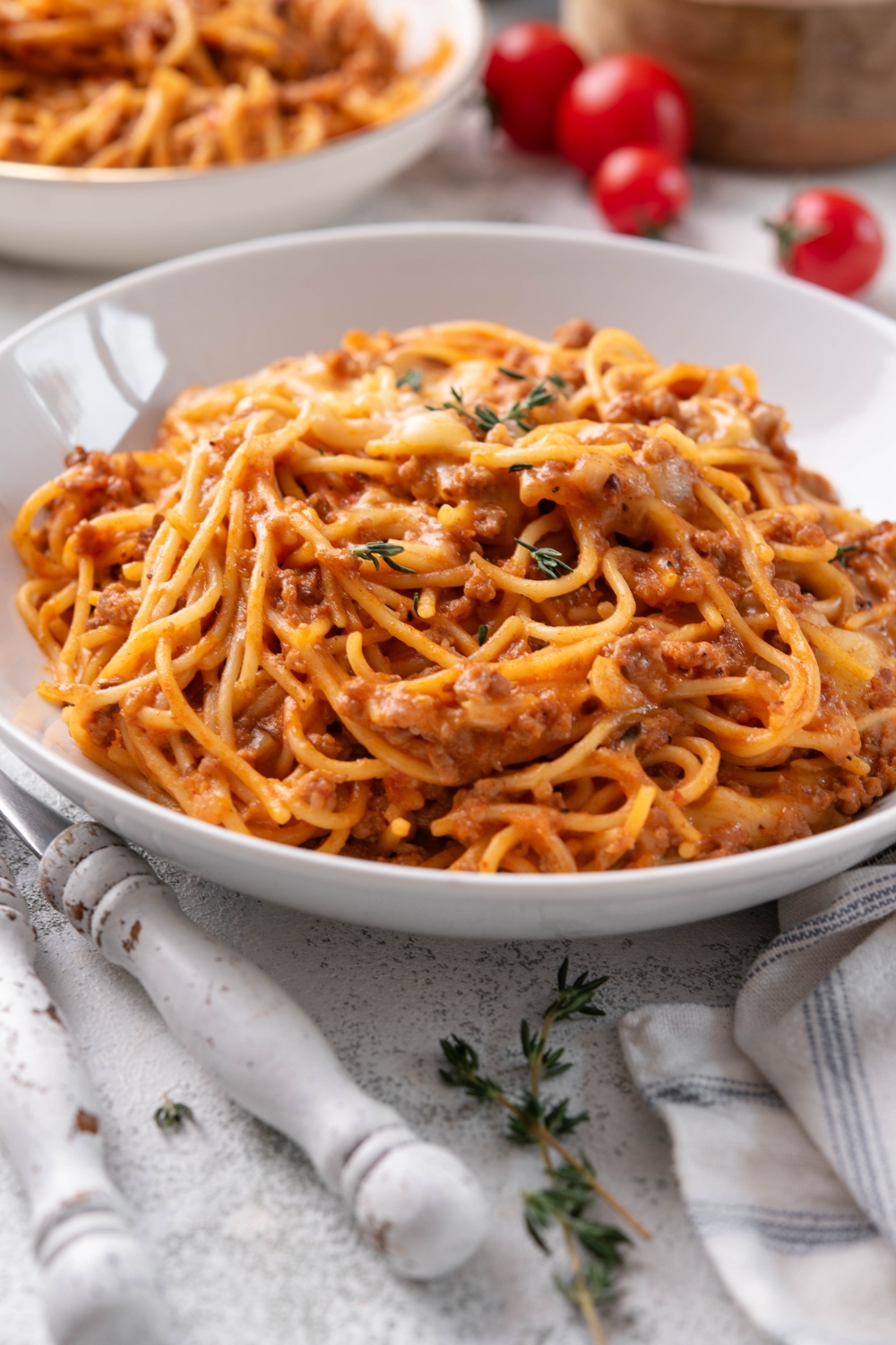 A bowl of spaghetti in a red creamy sauce with melted cheese and ground beef.