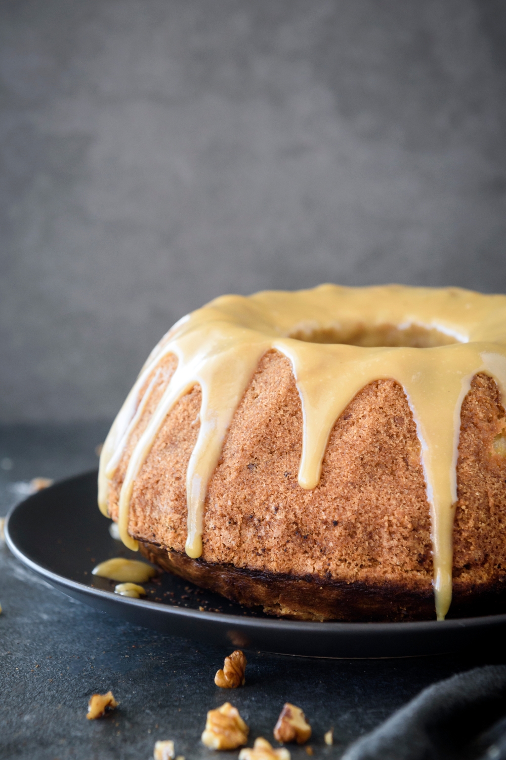 A bundt cake covered in a caramel glaze that is dripping down the sides of the cake.