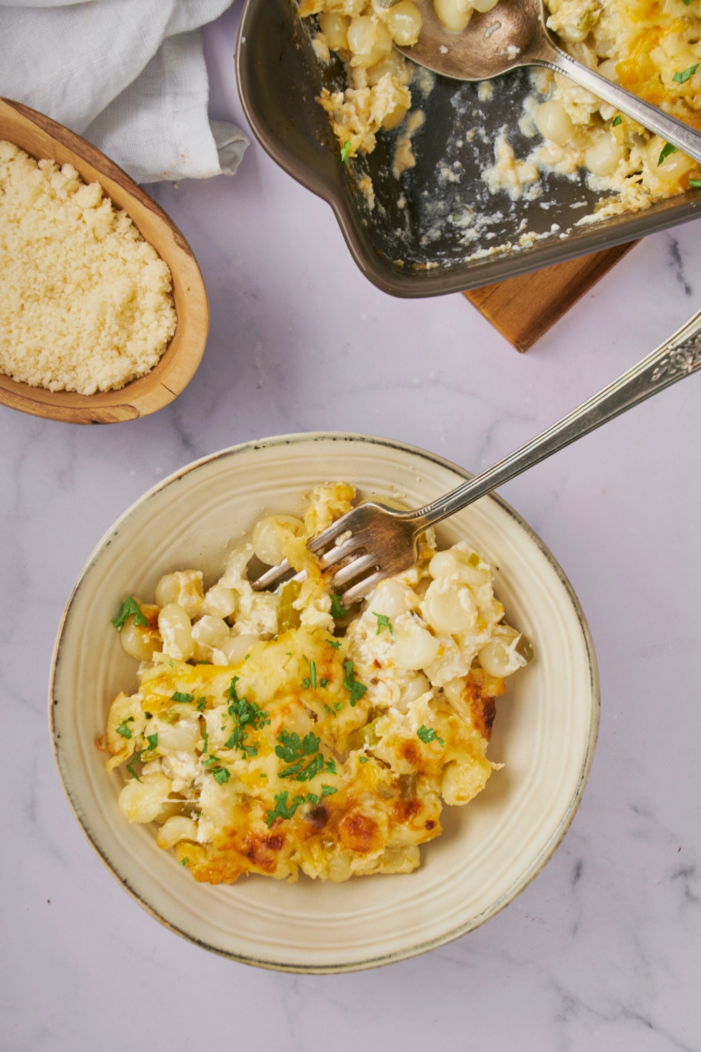 A white bowl of cooked hominy casserole.