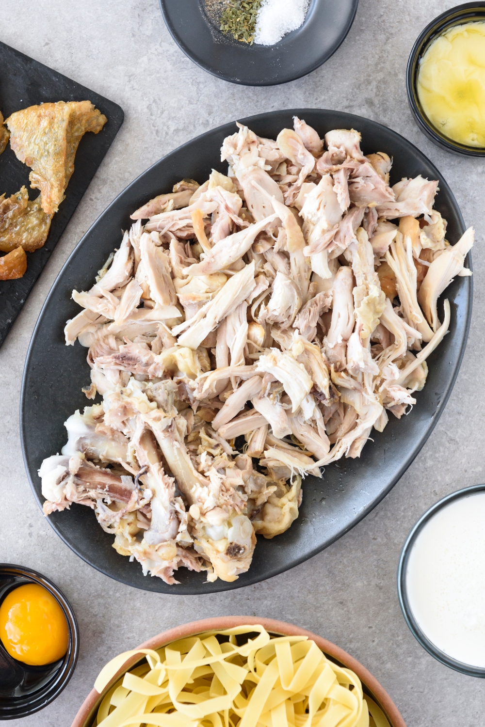 A serving plate filled with cooked and shredded chicken.