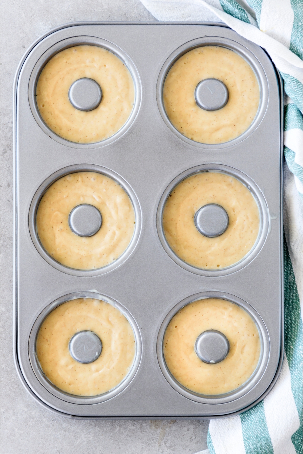 A doughnut baking pan with each spot filled with batter.