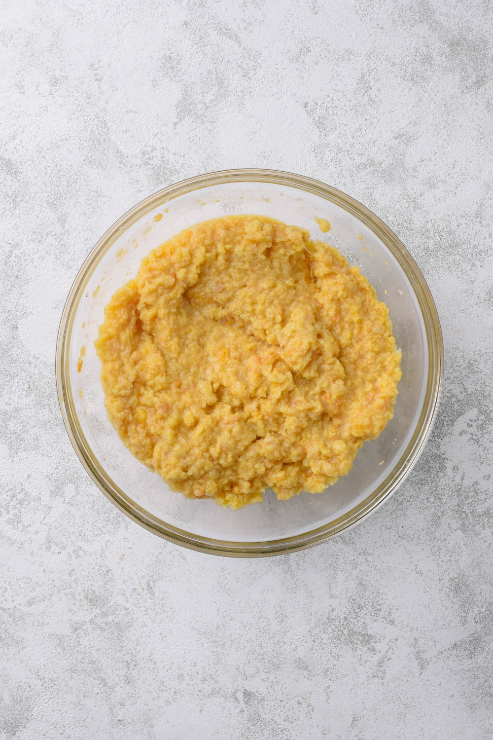 A clear bowl filled with a moist cornbread mixture.