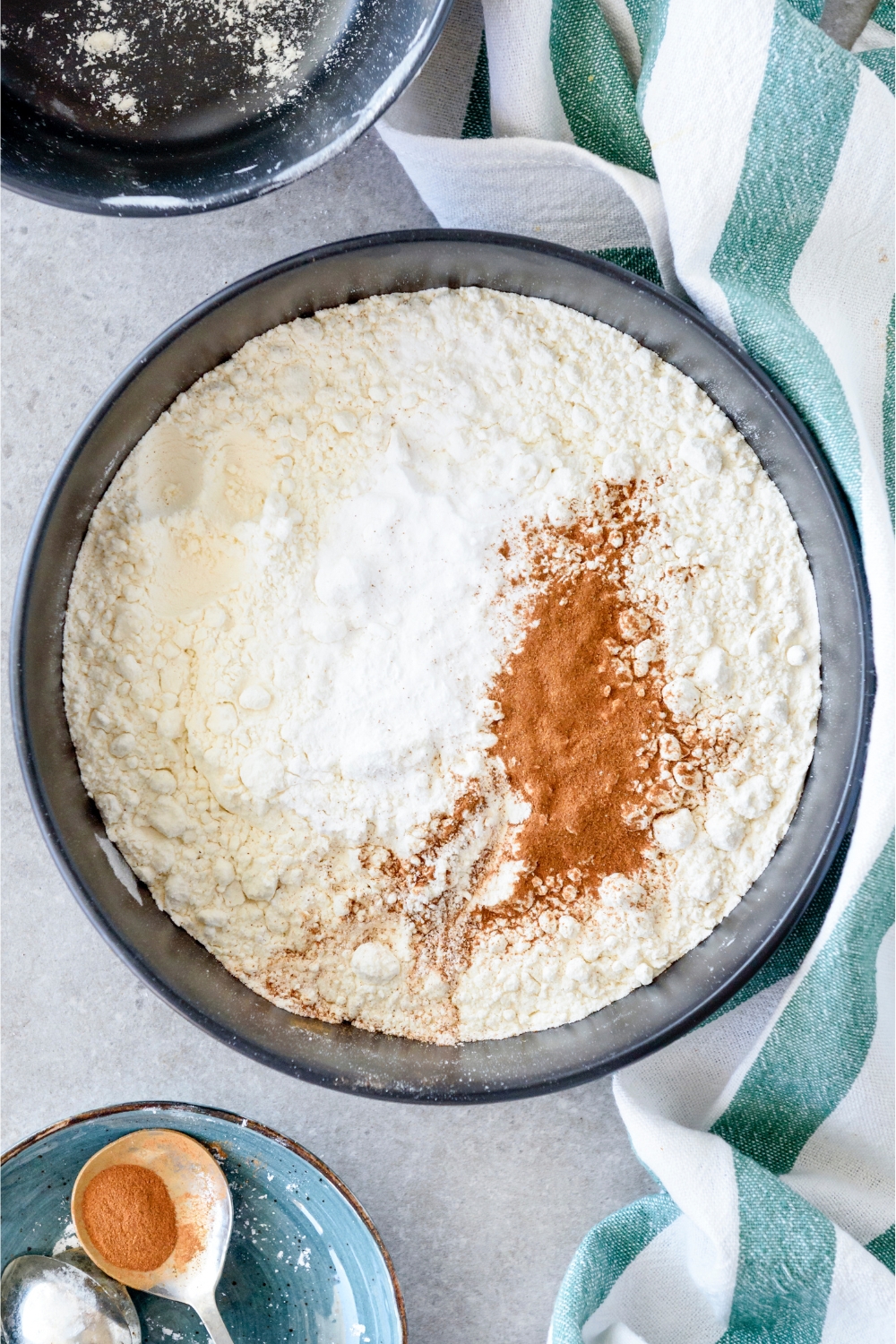 A bowl filled with flour, cinnamon, and baking powder.