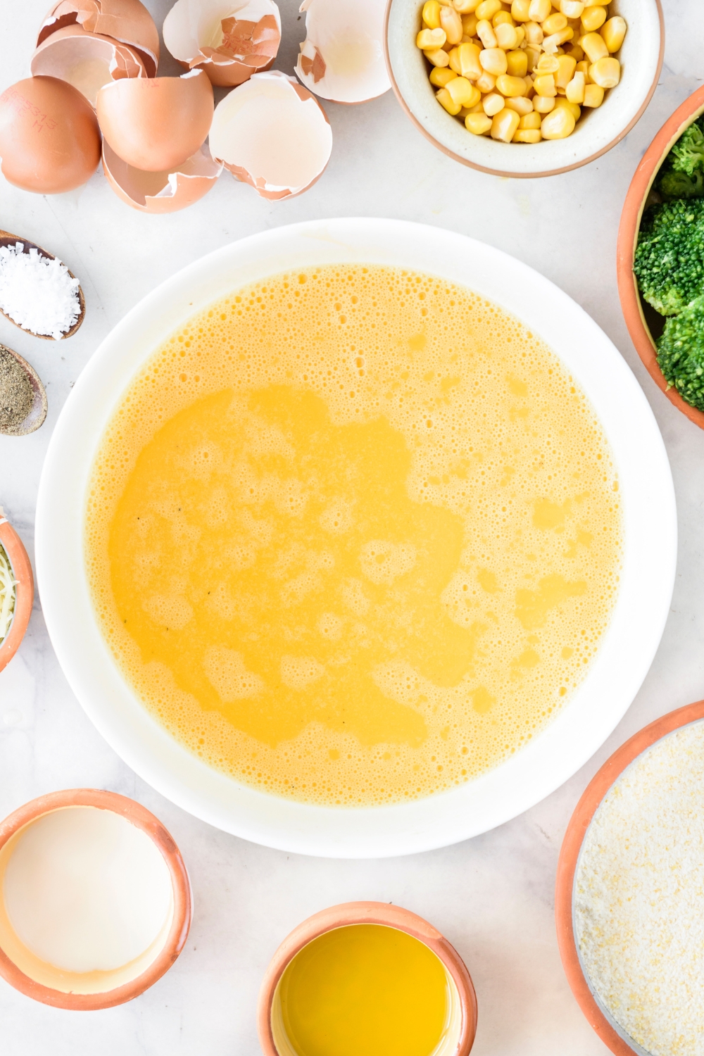 A large bowl filled with a beaten egg mixture.