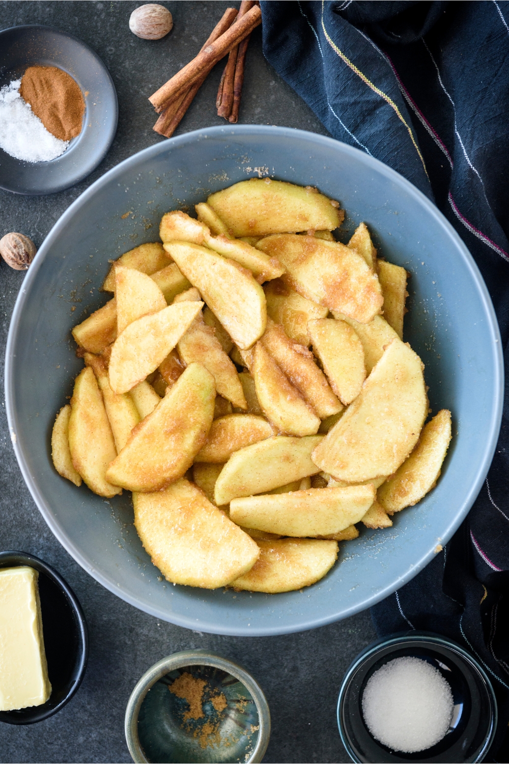 A bowl filled with apple slices coated in sugar and spices.