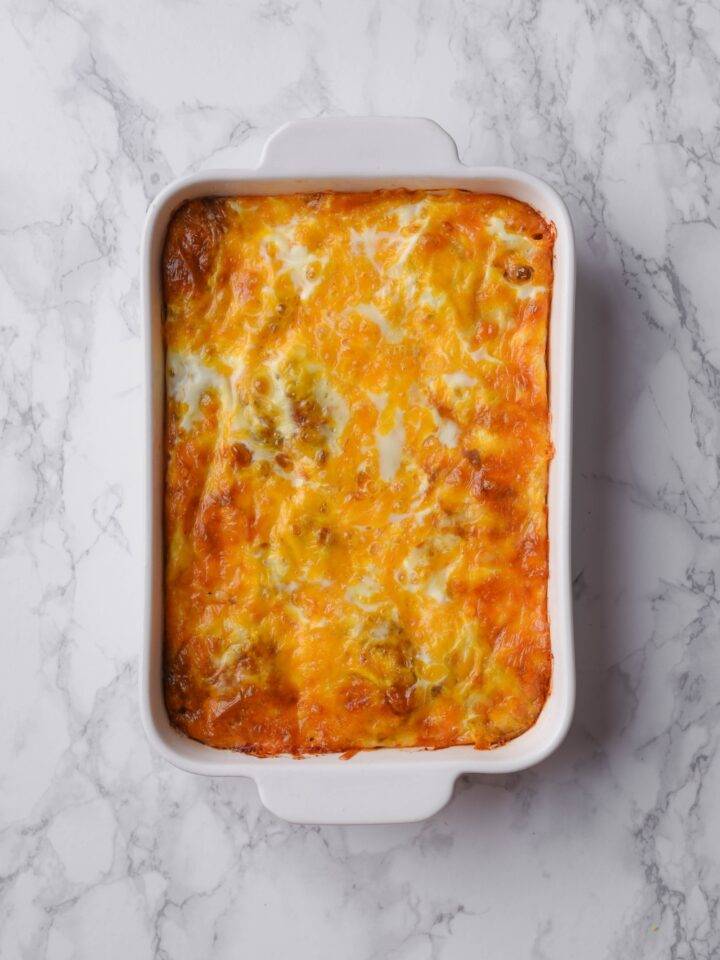 A baking dish filled with freshly baked casserole covered in melted cheese.
