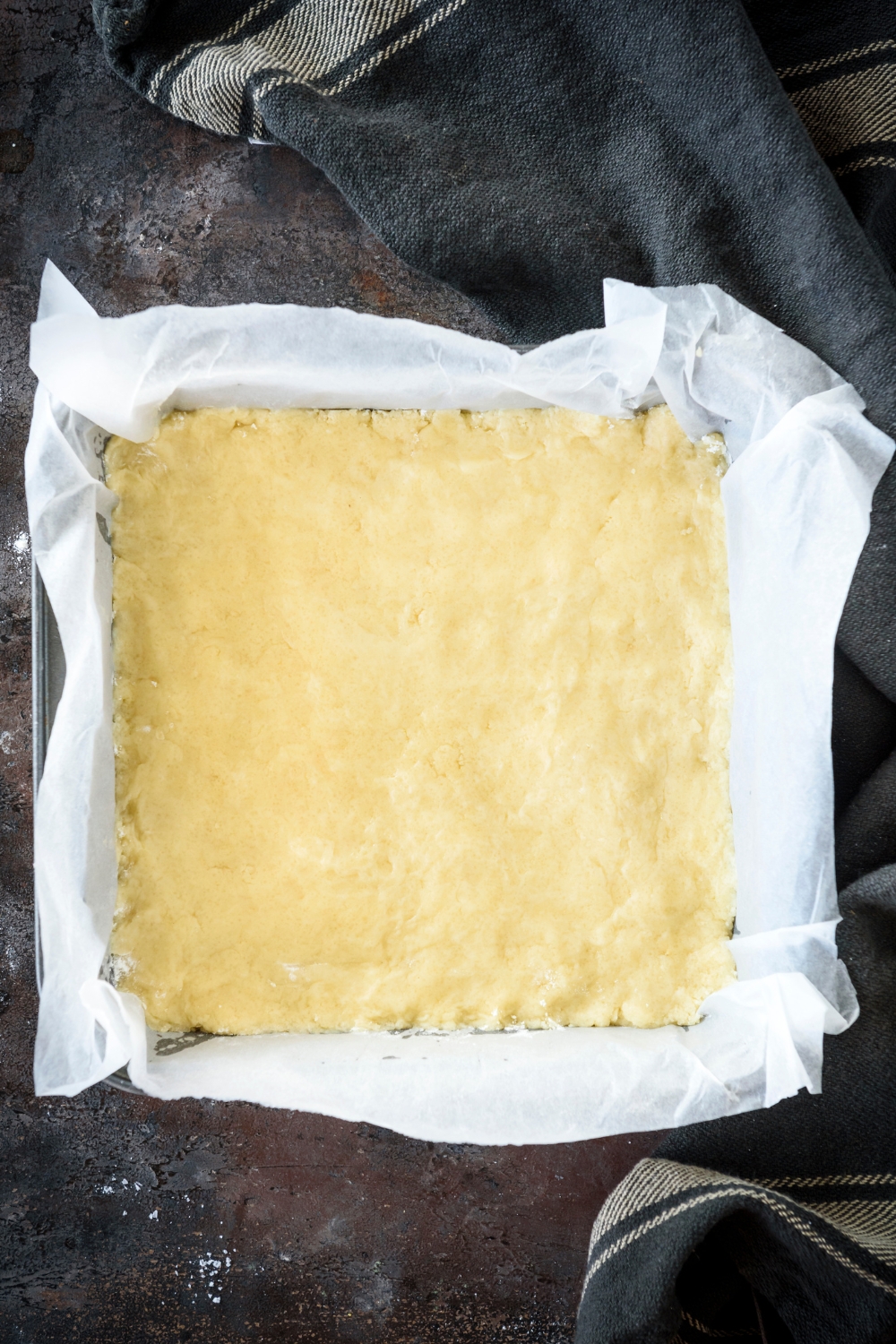 A square baking dish filled with biscuit dough.