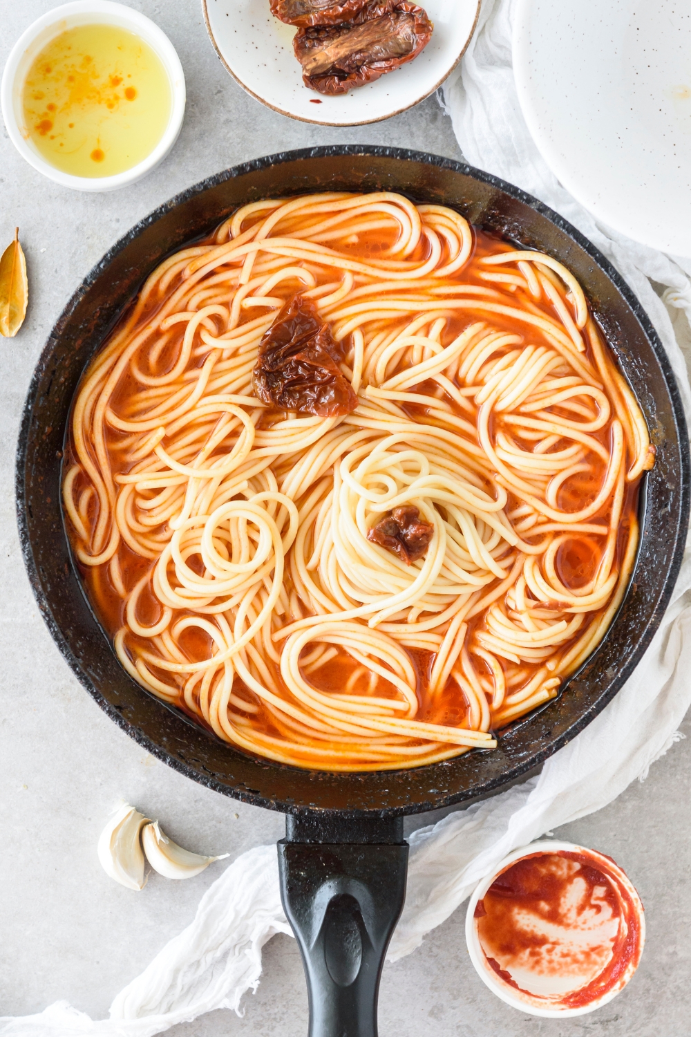 A skillet filled with spaghetti noodles in tomato sauce.