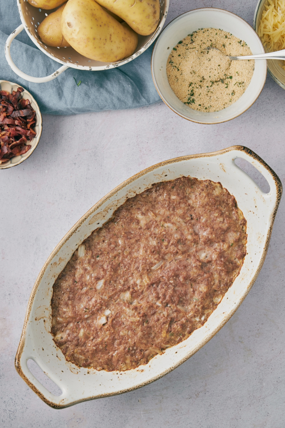 Brown meat mixture in a white casserole dish.