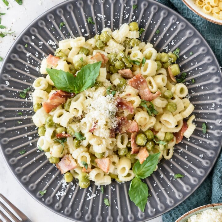 A bowl that is filled with pasta and peas.