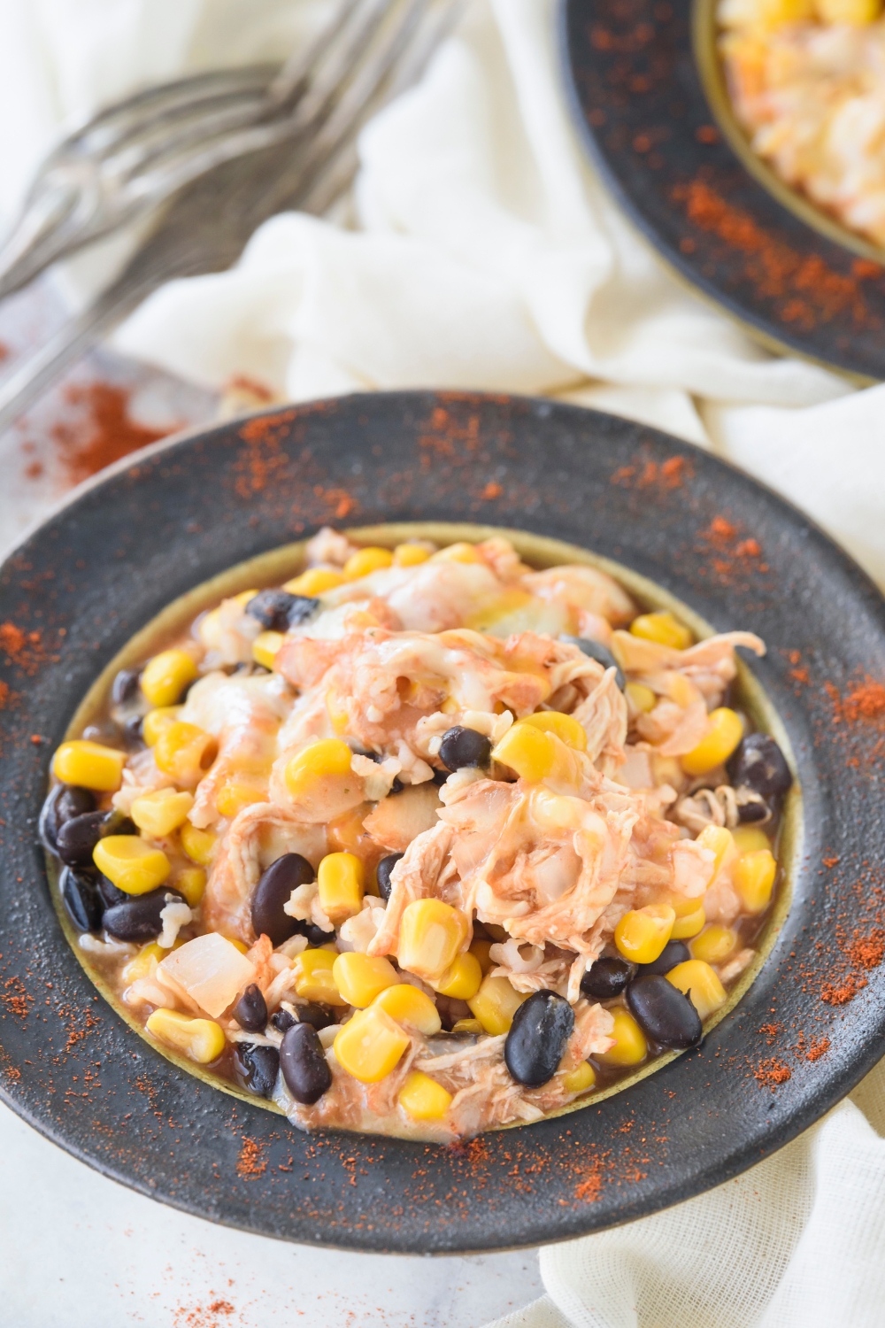 A bowl filled with shredded and seasoned chicken, corn, and black beans.